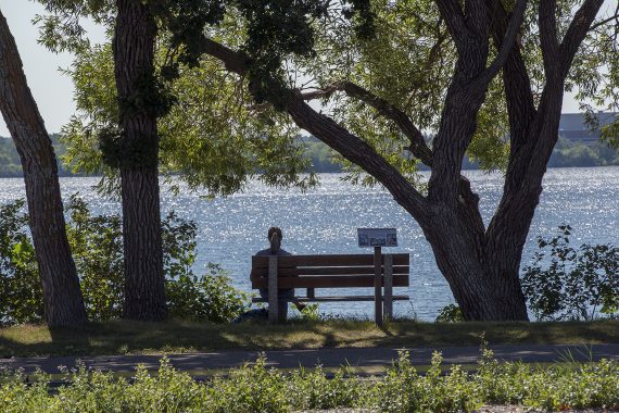 Student sitting on a bench in front of Lake Bemidji