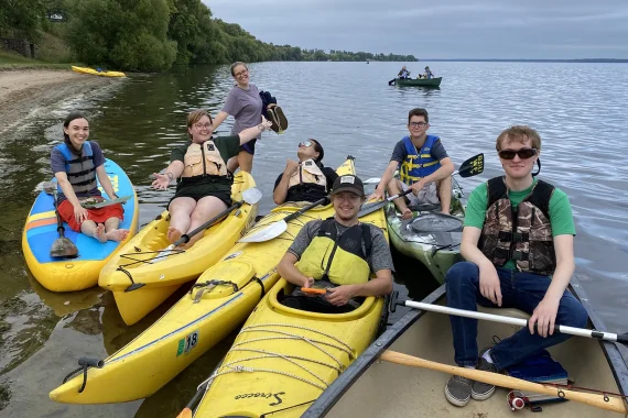 Students enjoying kayaking, canoes and paddle boarding on the shores of Lake Bemidji.