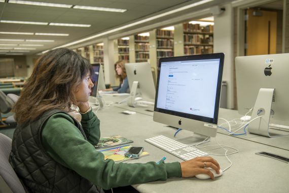 A student using a desktop computer in a library