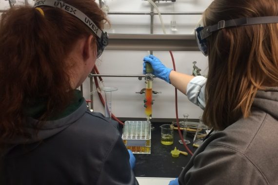 Two students using chemistry lab equipment