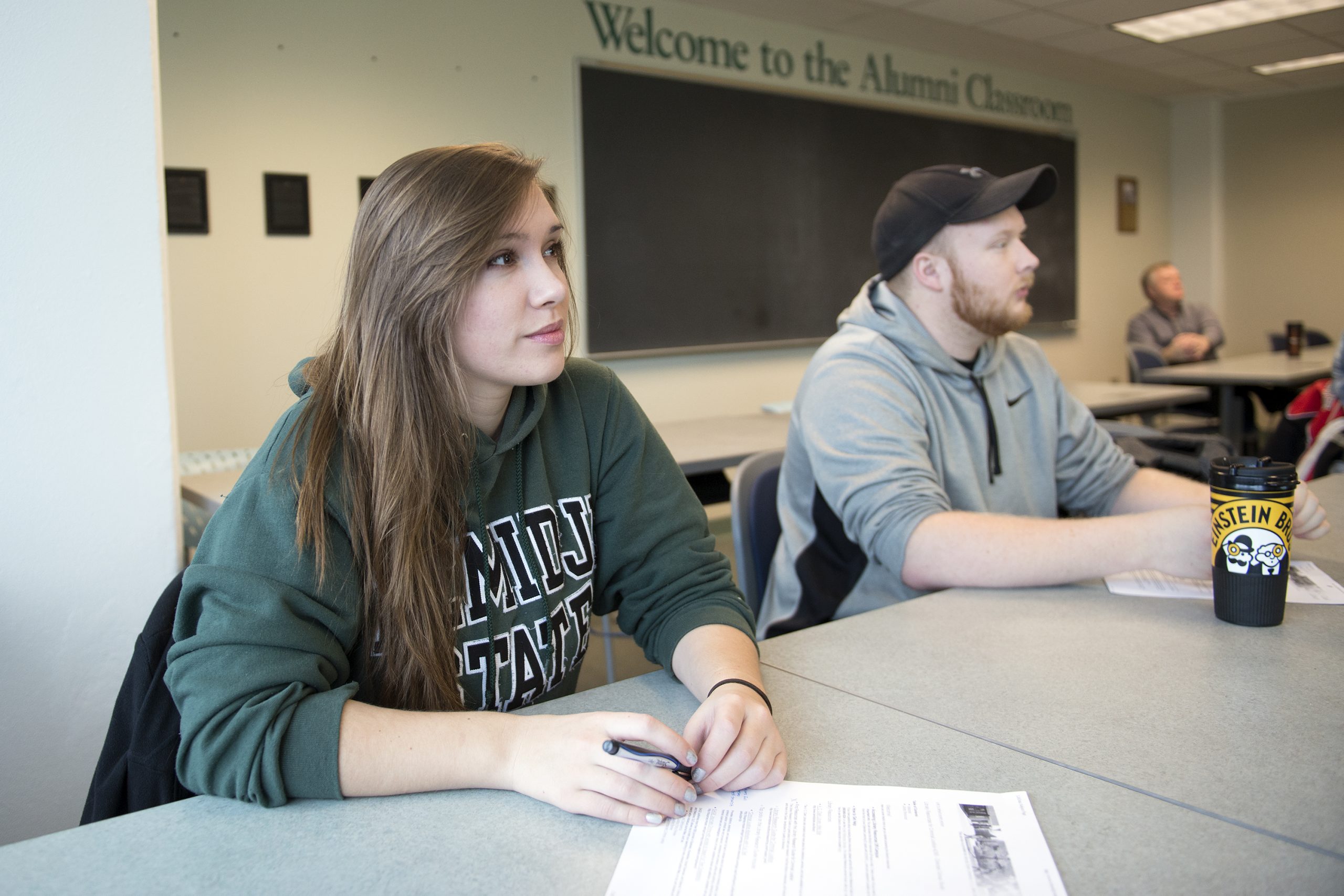 Two students sitting in the Alumni Classroom in the BSU Library, listening to a presentation