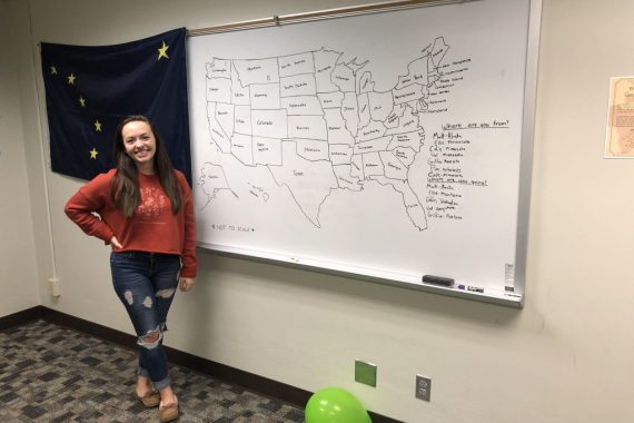 Student standing in front of a handdrawn map of the United States on a whiteboard