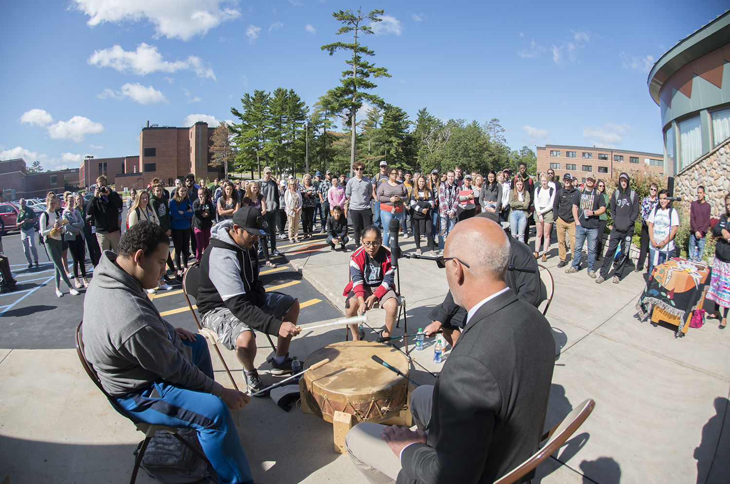 AIRC day of welcome in 2019, with people gathered in the parking lot surrounding a drum circle
