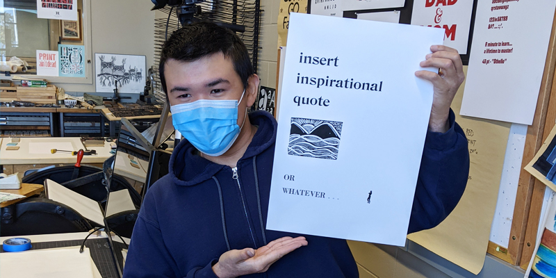 Benjamin Ng graphic design student at Bemidji State holding up a letterpress print