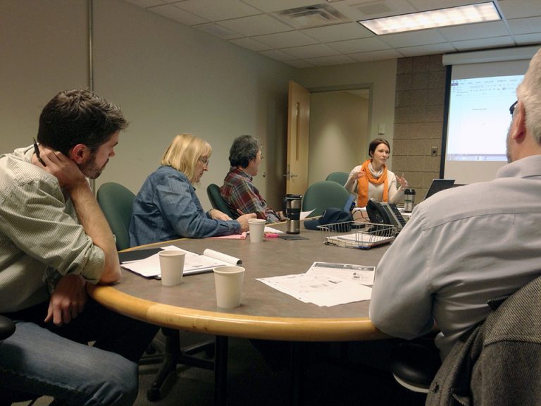 Faculty sitting at a conference table discussing