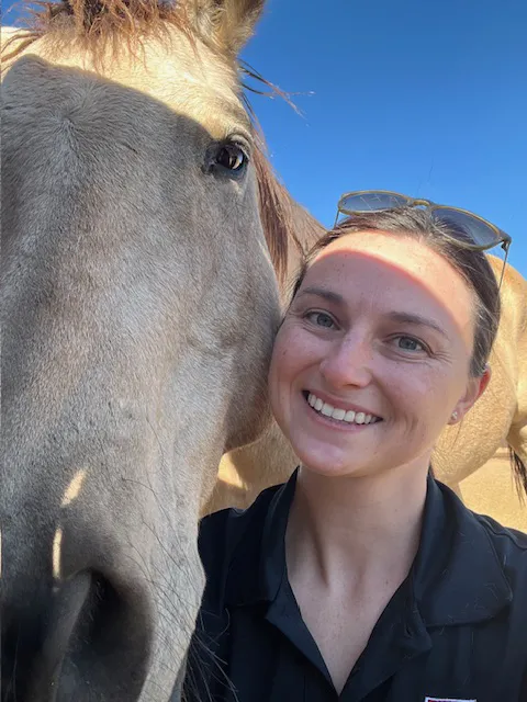 Headshot of Abe next to a horse.