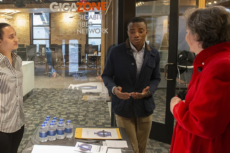 students presenting to a woman at a conference