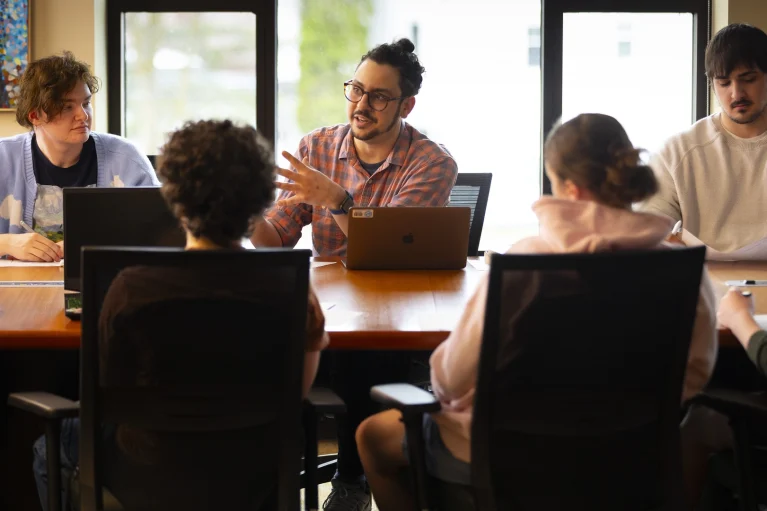 A faculty member teaching around a conference table