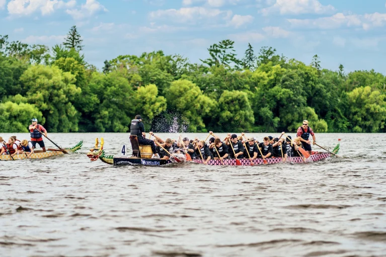 Two dragon boat teams racing on Lake Bemidji