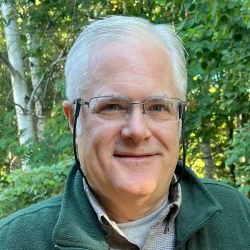 Headshot of Mike with a green backgroud.
