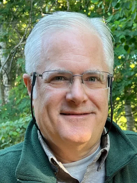 Headshot of Mike with a green backgroud.