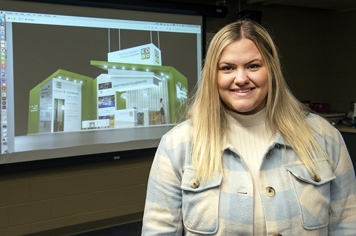 Anika Norgren standing in front of a projector screen