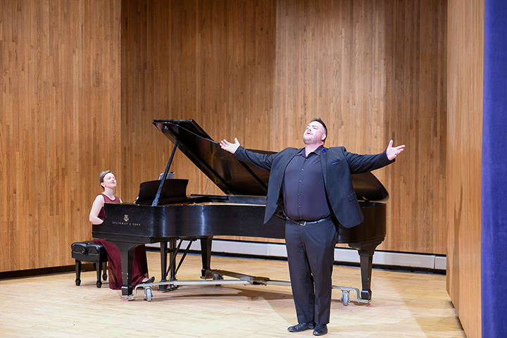 Dr. Brandon Hendrickson and Elena Lacheva performing on a stage