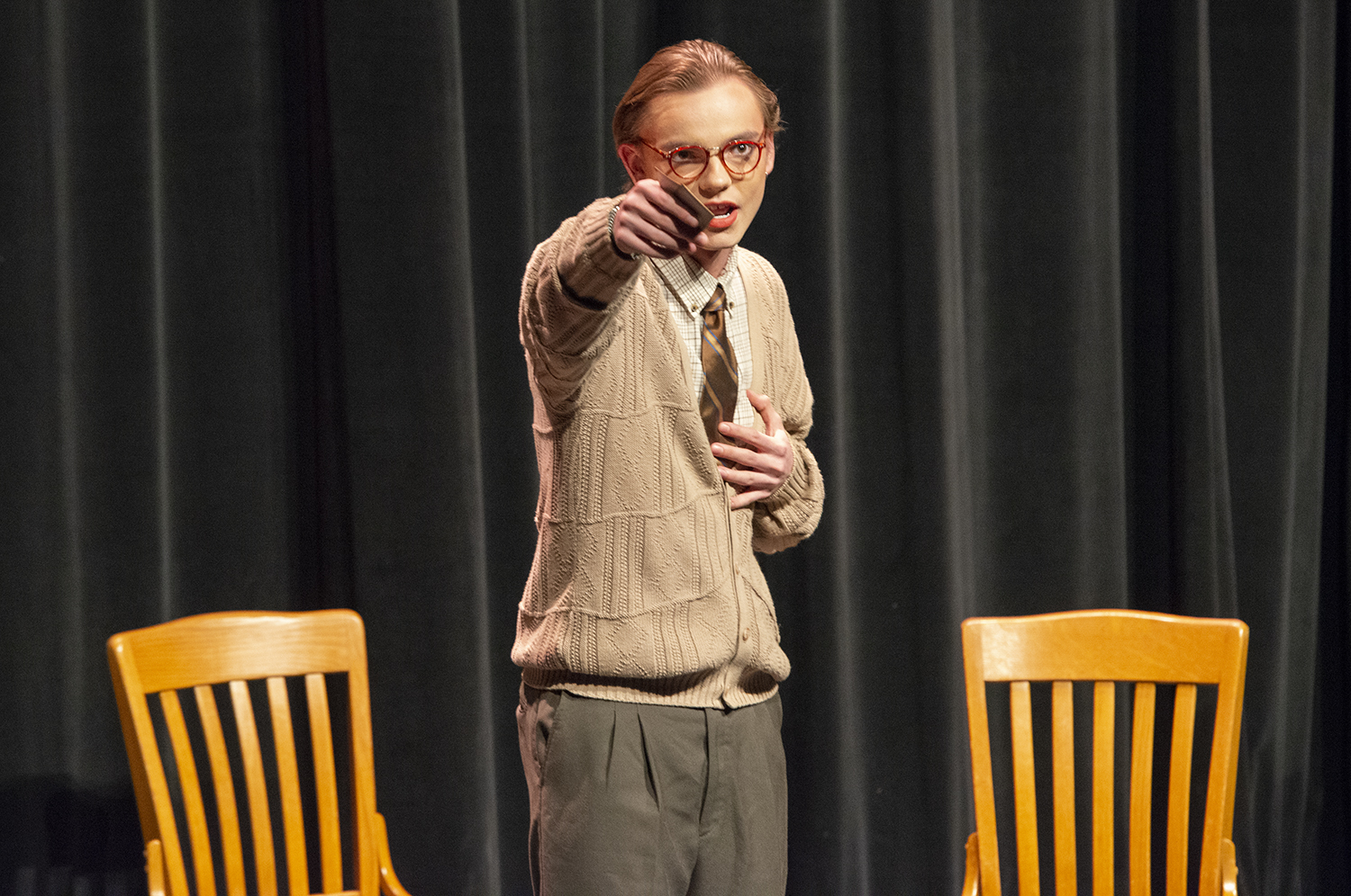 Performance of "A Hand of Bridge", a man holds cards in his hands and gestures to audience