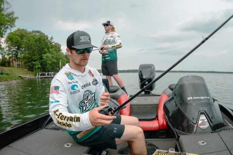 Student fishing in boat holding a rod