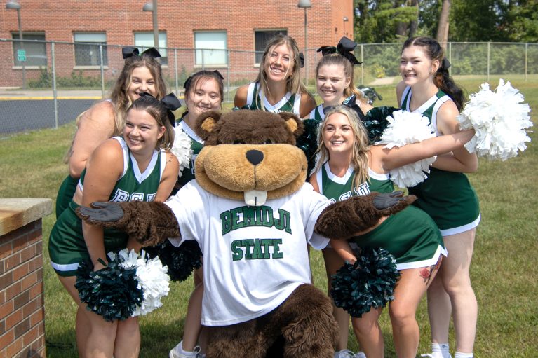 Bucky the beaver mascot surrounded by cheerleaders.