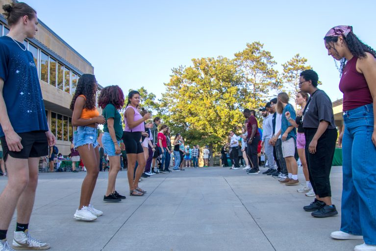 students in a line on both sides with people in the middle