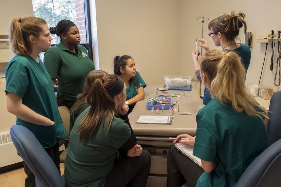 BSU nursing students talking around a table in the lab