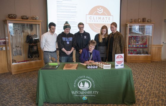 President Faith Hensrud signs Second Nature's Climate Commitment