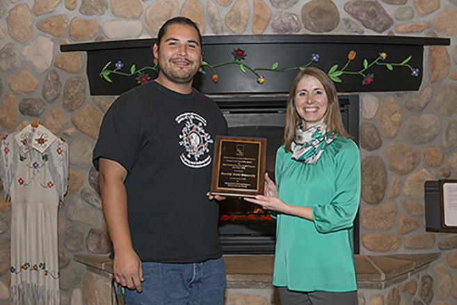 American Indian student leader Vincent Staples-Graves and Summer Program Director Angie Gora show off a plaque from the North American Association of Summer Sessions, which recognized BSU’s new Ojibwe Language Summer Camp for innovation.
