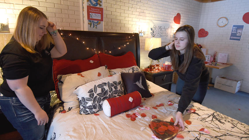 Courtney Peterson, a senior community health major at BSU, left, along with Mercideze VanBruggen, a freshman social work major, arrange a romantic bedroom display in the lower Hobson Memorial Union on Wednesday at BSU. The display was part of events during Sexual Responsibility Week on campus. (Jillian Gandsey | Bemidji Pioneer)