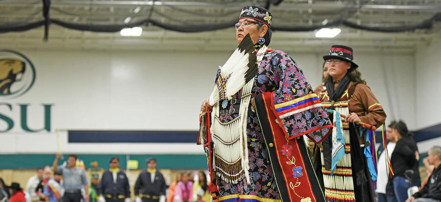 Women walk in during the grand entrance of the 44th Annual BSU Powwow hosted by the Council of Indian Students on Saturday in the John Glas Fieldhouse.
