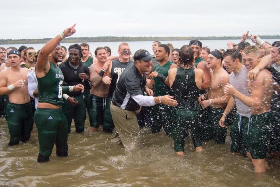 Coach Bolte joins his players in a traditional lake plunge to celebrate their 40-22 victory over Southwest Minnesota State.