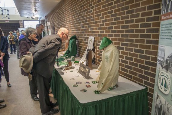 Dr. Jim Barta, dean of the College of Arts, Education & Humanities, and scholarship donors Geri and Darby Nelson inspect artifacts from the A.C. Clark Library archives at the &ldquo;History Walk&rdquo; on April 12.