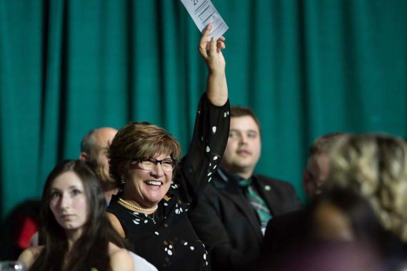 Terri Thomas pledges in support of athletic scholarships during the live auction.