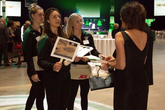 Women&rsquo;s Hockey teammates sell paddles for Heads and Tails.