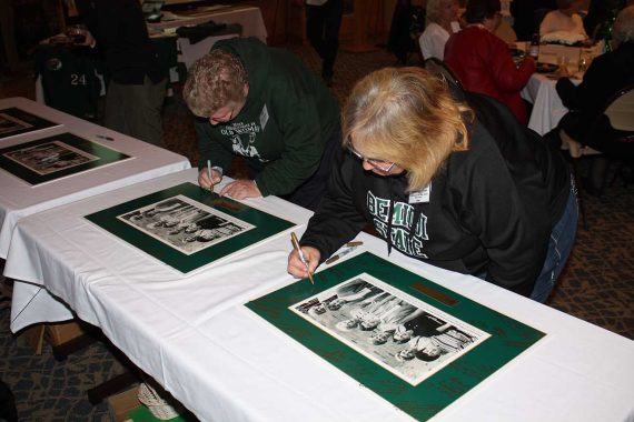 Alumnae add their signatures to photos presented to the Founders
