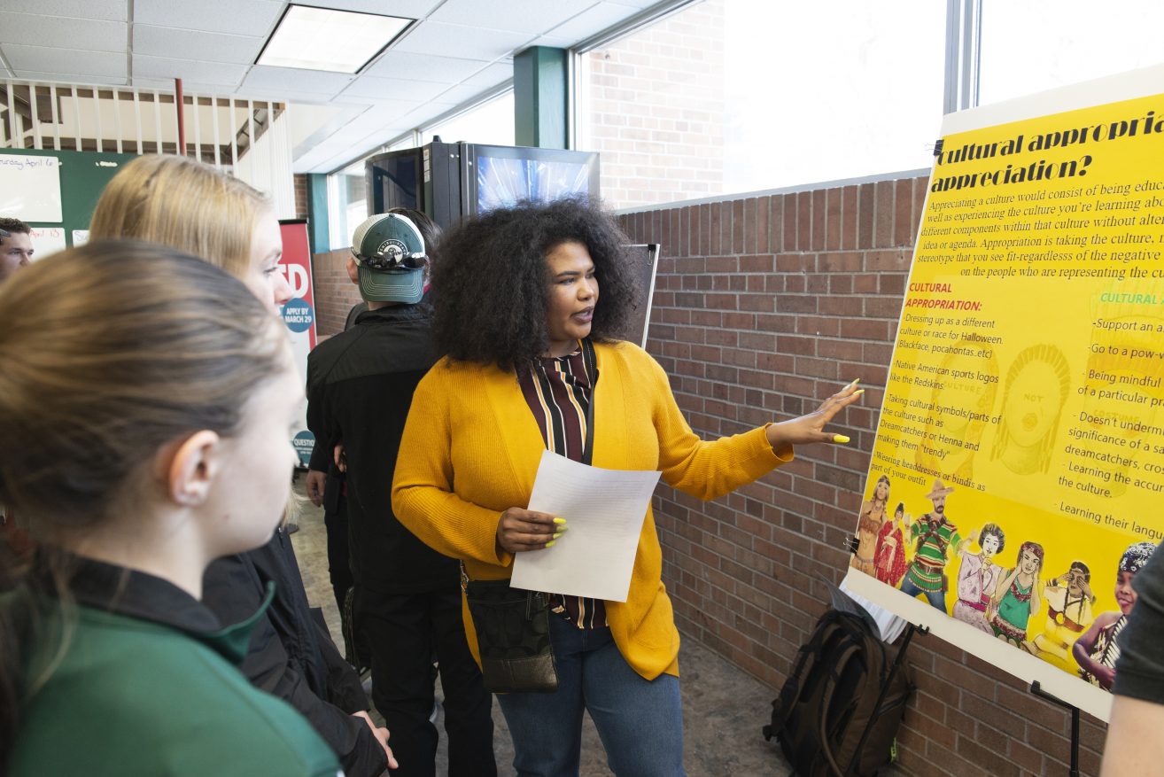A student presenting her poster during the Student Achievement Conference