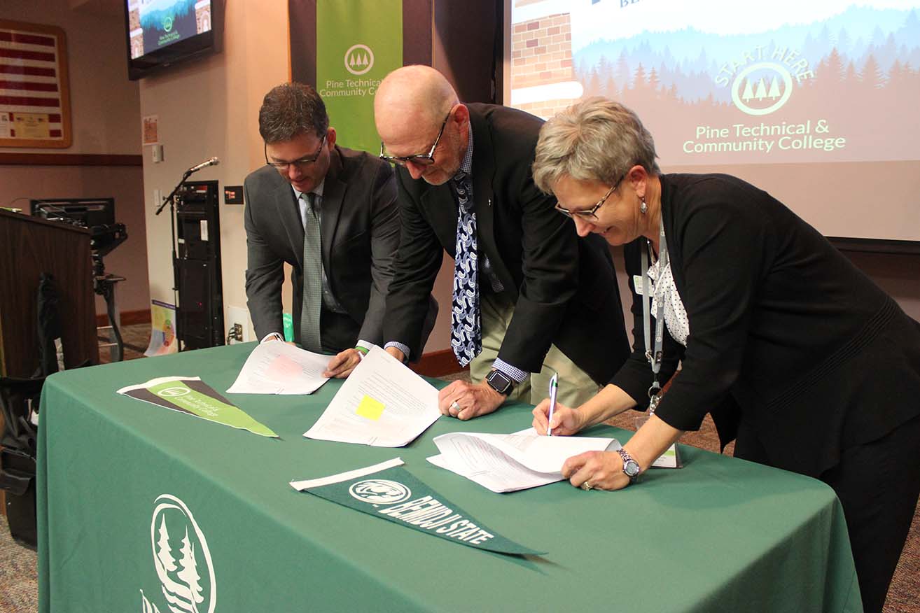 BSU and Pine Tech administrators sign a transfer agreement.