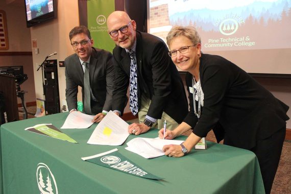 BSU and Pine Tech administrators sign a transfer agreement.