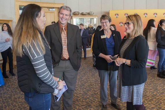 Peggy Flanagan, Darrin Strosahl and President Faith C. Hensrud speaking with NTC student Allanah Weitzel.