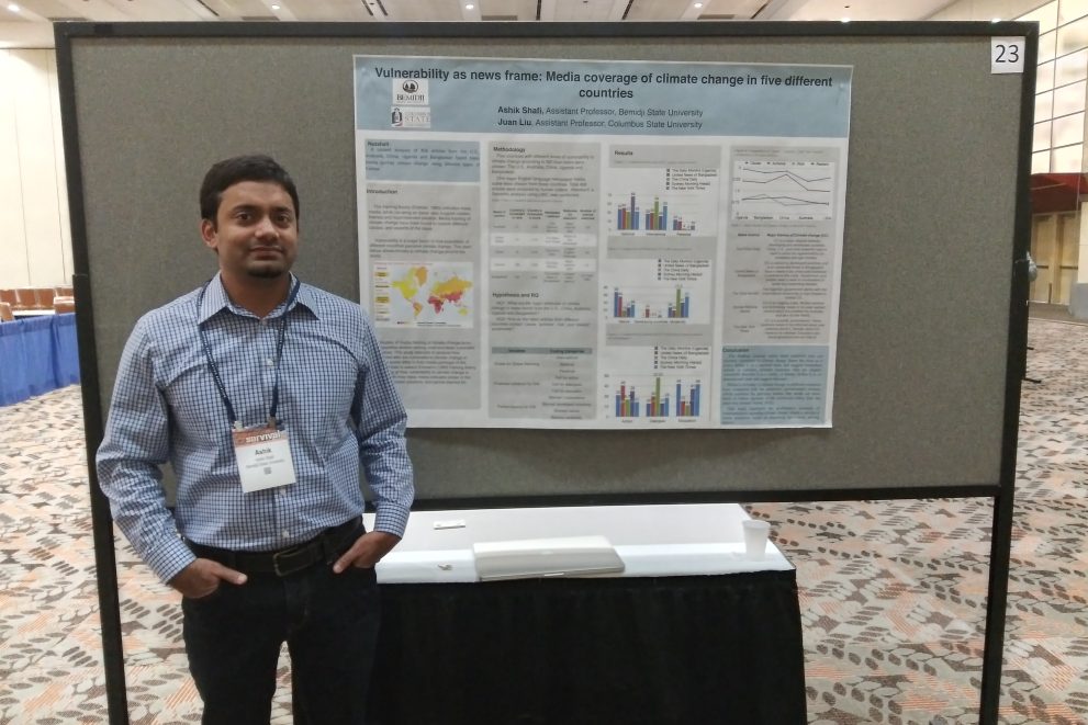 Dr. Ashik Shafi standing with his presentation poster.