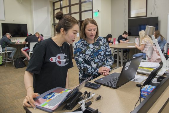 A business student learns from Dr. Angie Kovarik, assistant professor of business