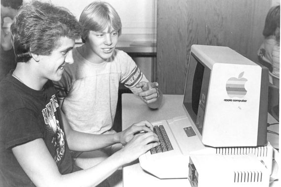 Students use an Apple II computer, 1980s.