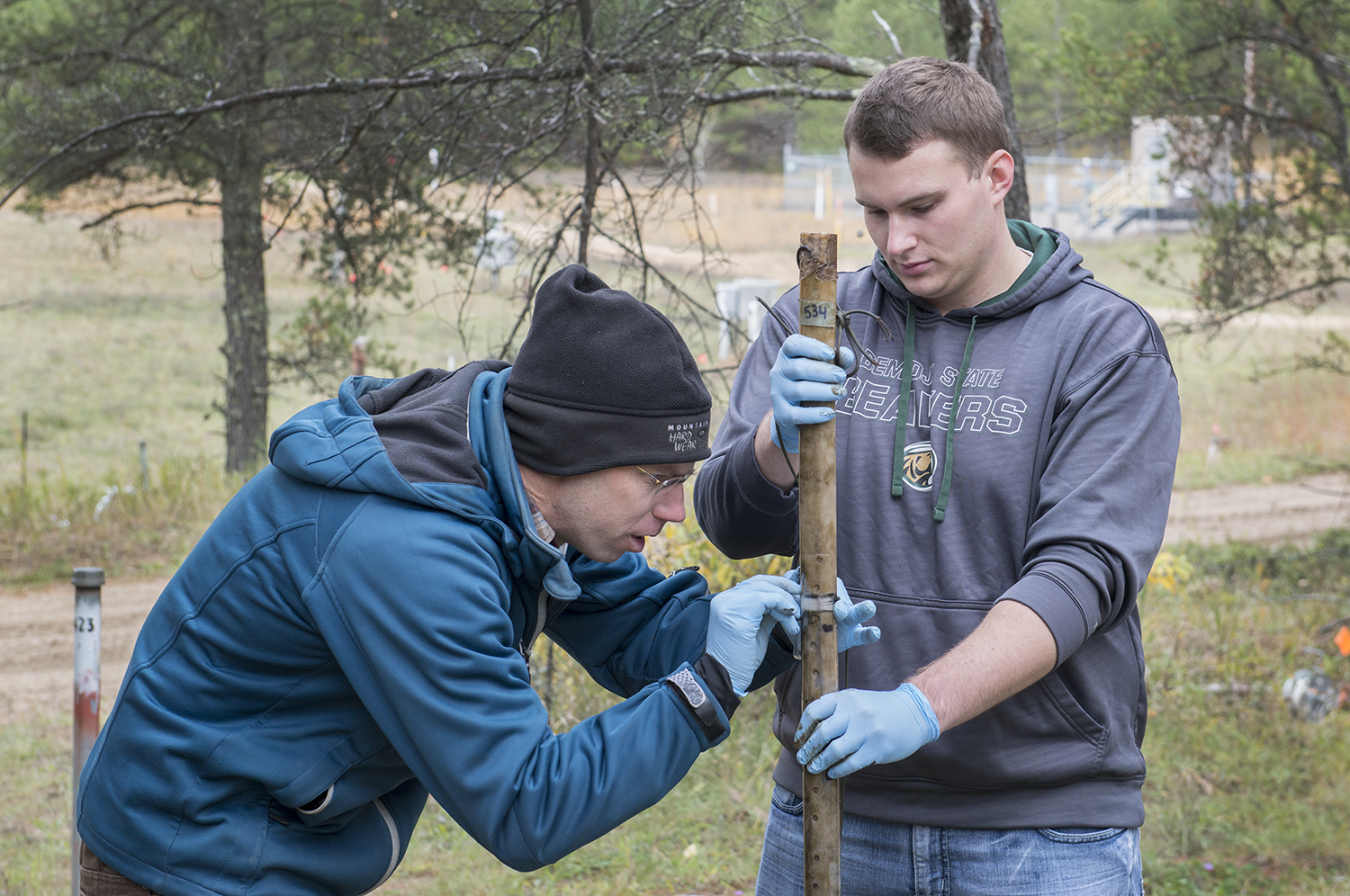 Dr. Carl Isaacson, associate professor of environmental studies, and BSU students conducting research on microorganisms at an oil spill site in Pinewood, Minn.