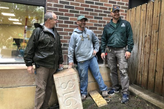 Brian Ingalls, Brent Steinmetz and Mitch Bannor pose with the Deputy Hall cornerstone after locating the time capsule.