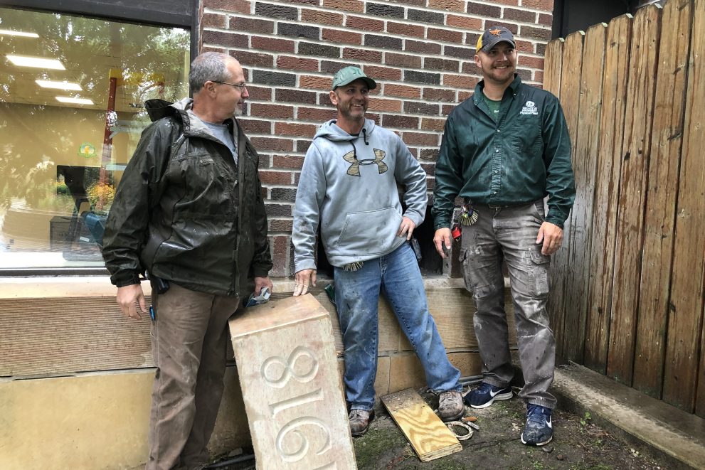 Brian Ingalls, Brent Steinmetz and Mitch Bannor pose with the Deputy Hall cornerstone after locating the time capsule.