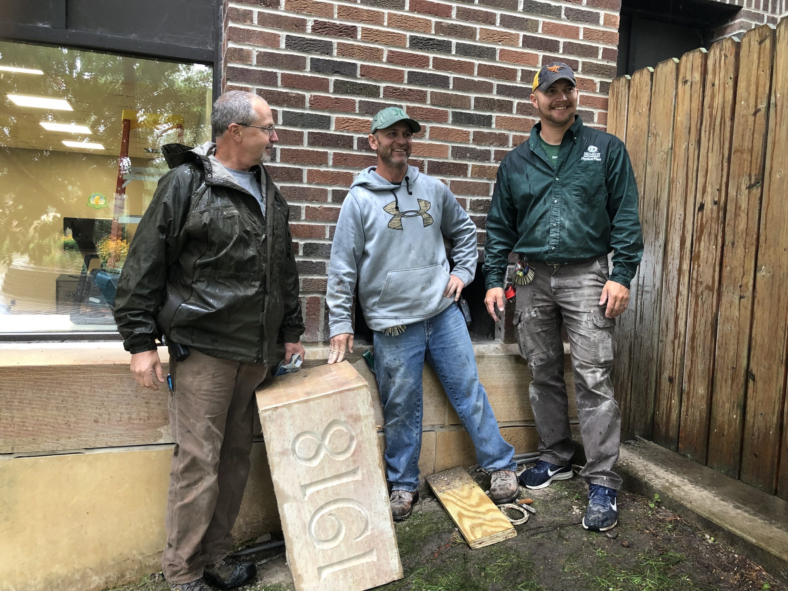 Brian Ingalls, Brent Steinmetz and Mitch Bannor pose with the Deputy Hall cornerstone after locating the time capsule.