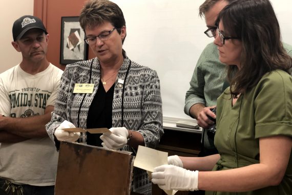 President Hensrud and Colleen Deel examine the capsule’s contents.