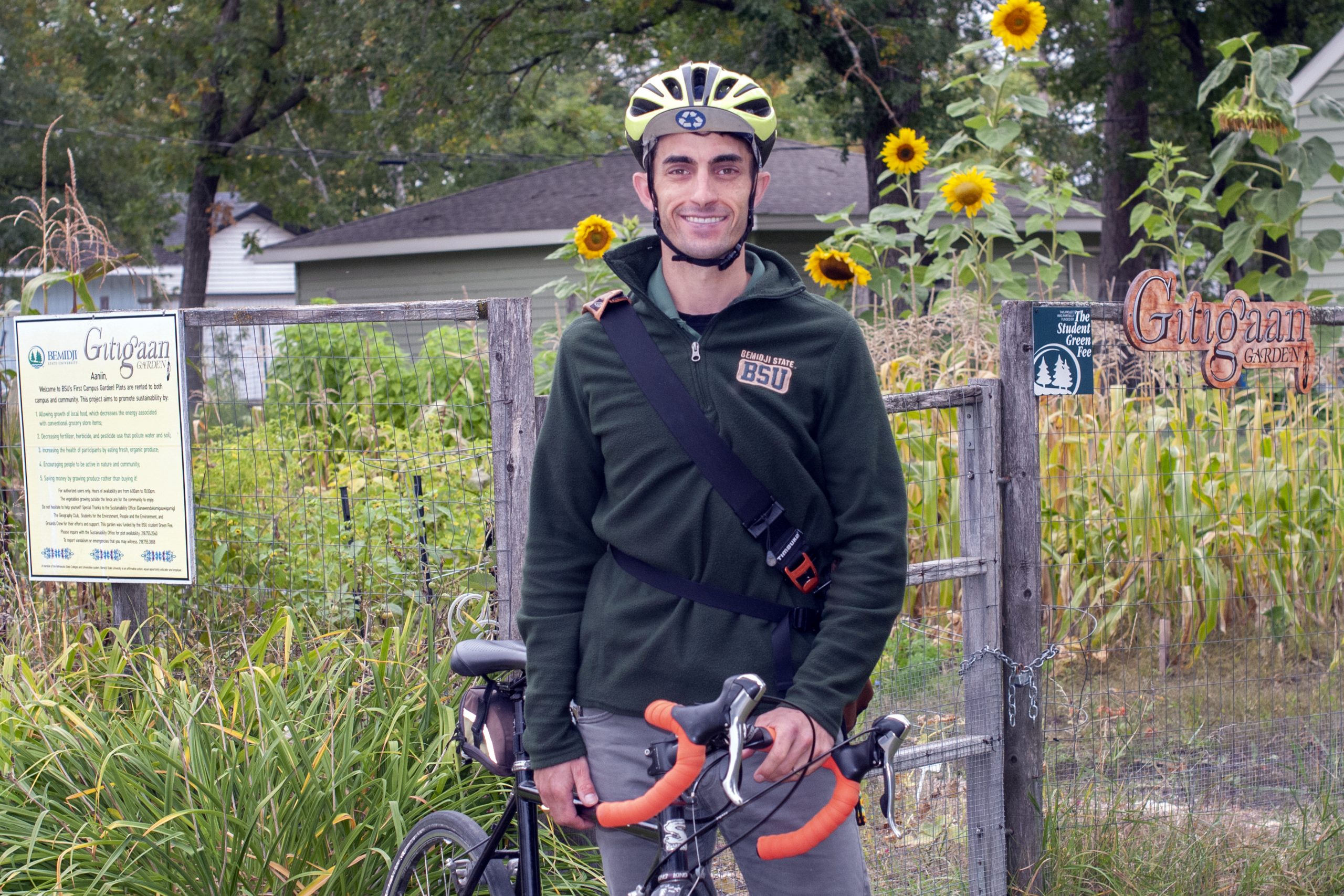 Jordan Lutz with his bike standing in front of our campus garden