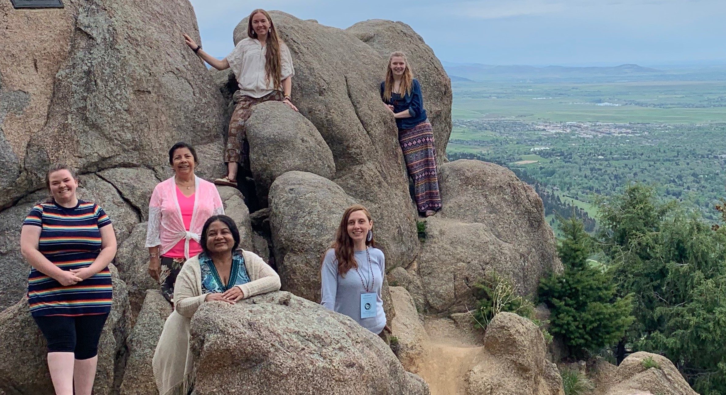 Michell Holbeck (’20, left) and Anna Haynes (’20, right, on rock), Niizhoo-gwayakochigewin communication and design interns joined Niizhoo collaborative members Dr. Vivian Delgado, Dr. Cornelia Santos, Erika Bailey-Johnson, and Kim Shelton at the Rising Voices workshop in Boulder, Colorado, in May of 2019.