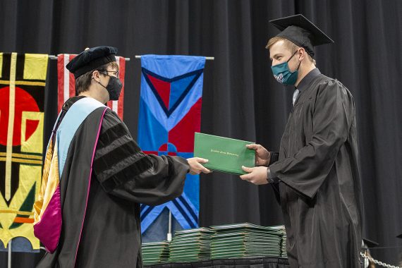 President Faith C. Hensrud confers a diploma