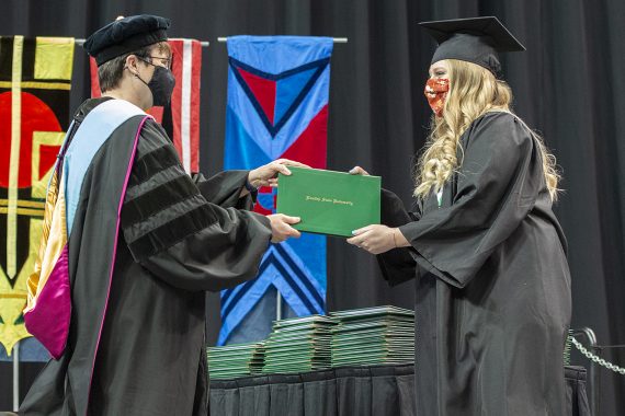 President Faith C. Hensrud confers a diploma