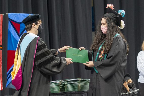 President Faith C. Hensrud confers a diploma