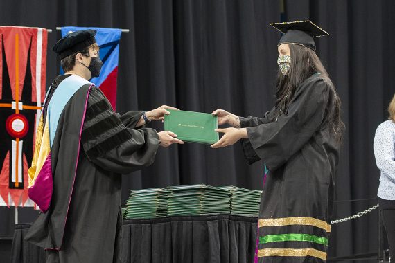 President Faith C. Hensrud confers a diploma