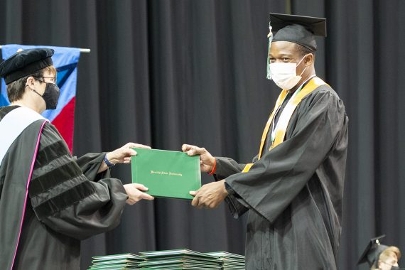 President Faith C. Hensrud confers a diploma